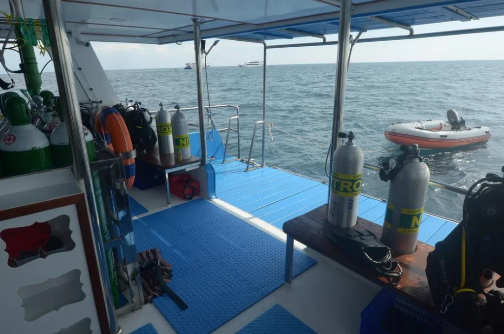 Divers prepare with enriched air nitrox cylinders aboard a liveaboard dive boat