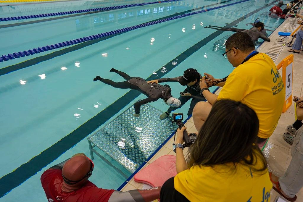 Freediver remains motionless during a supervised static apnea competition in a swimming pool