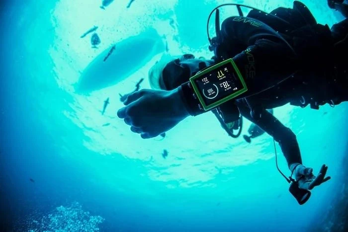 Diver checks depth and no-decompression limit on an underwater dive computer
