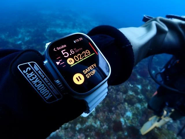Scuba diver monitors a dive computer while completing an underwater safety stop